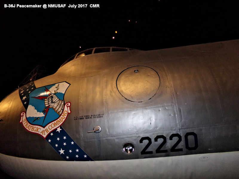 Close‑up view of the nose section of a B‑36J Peacemaker on display at the National Museum of the U.S. Air Force, showing its metallic finish, cockpit windows, Strategic Air Command shield, and the number “2220” painted near the lower fuselage. 